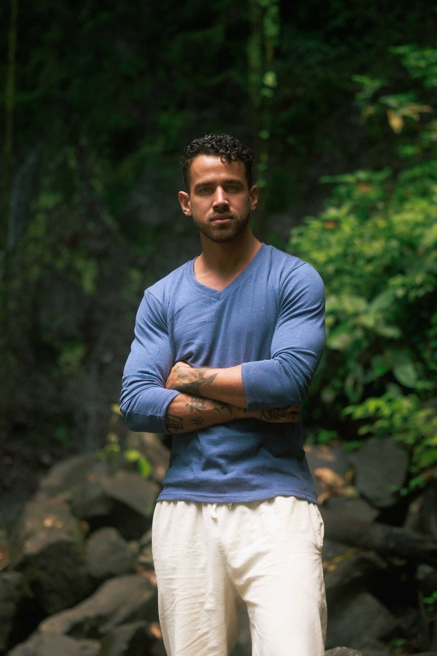 Men's blue hemp long sleeve V-neck shirt, eco-friendly and durable, worn in nature setting.