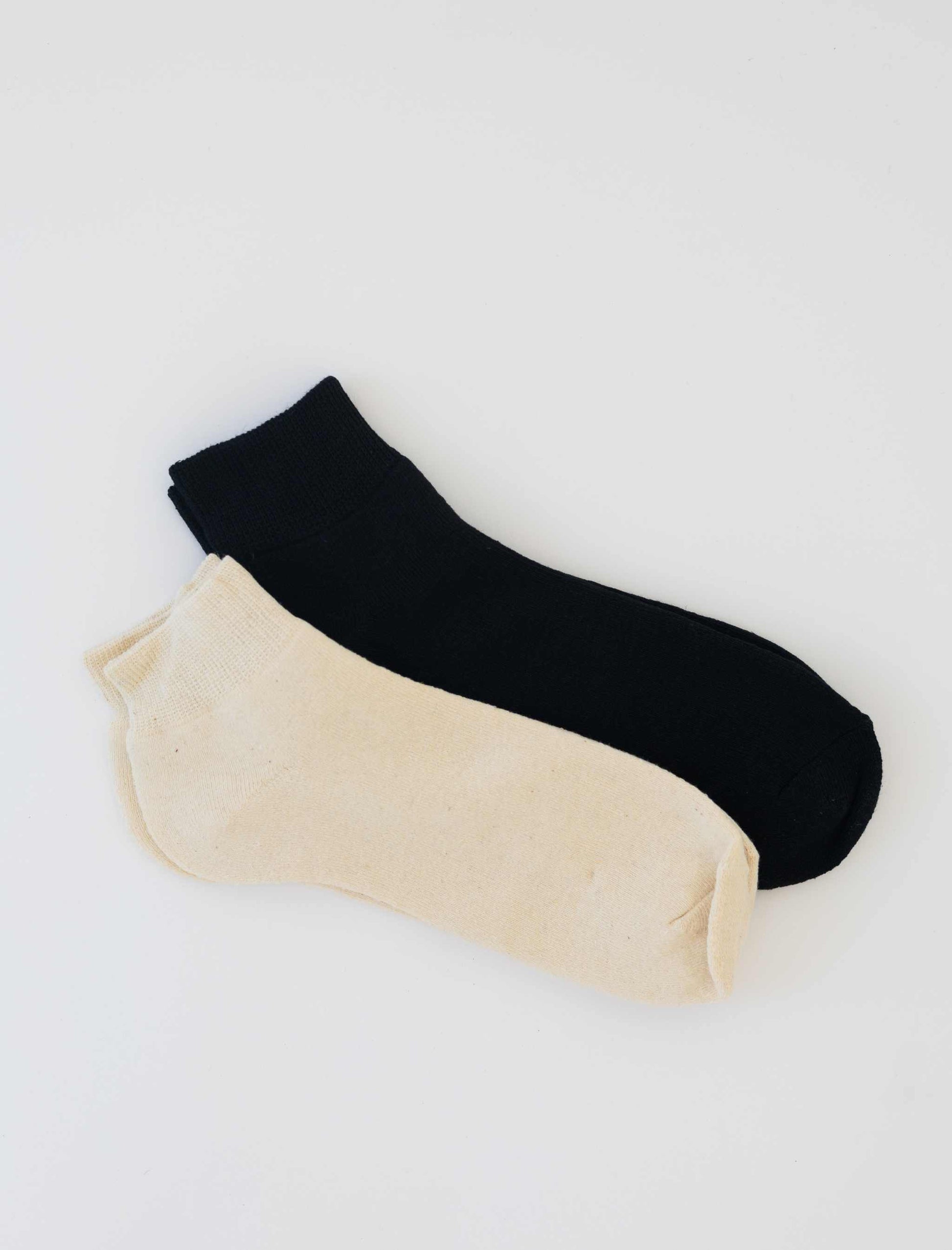 Pair of women's hemp socks in natural and black colors, ankle length, made from hemp and organic cotton blend.