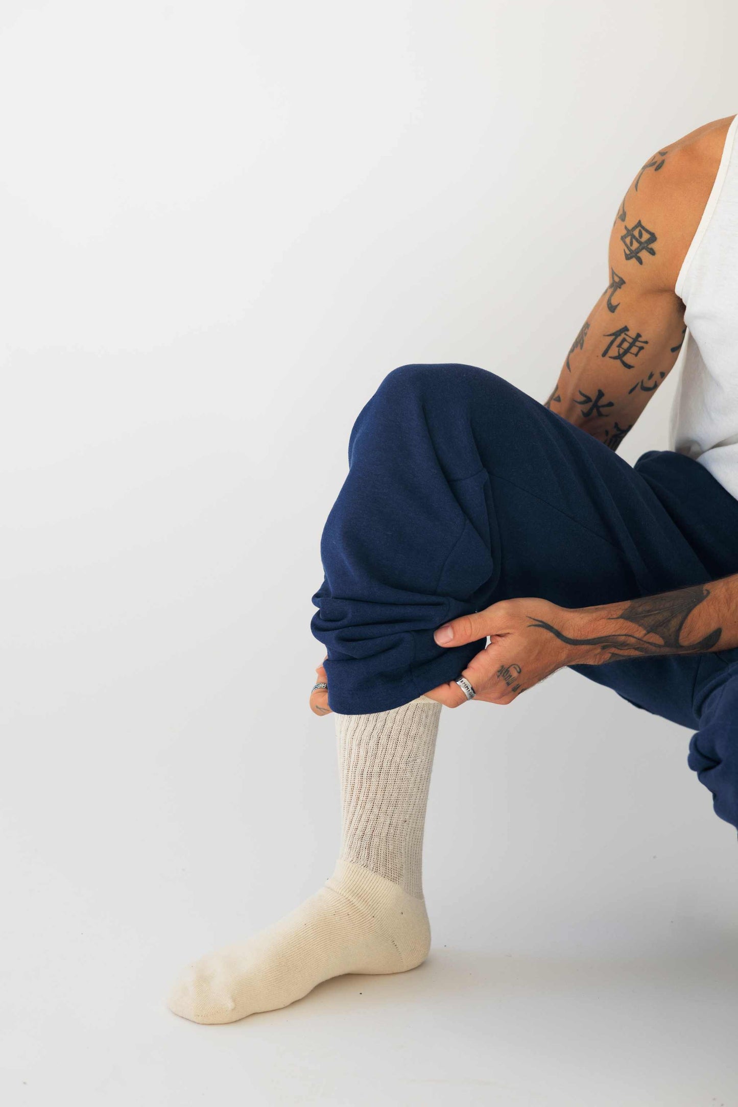 Men's organic cotton calf socks in natural color worn with blue pants. Eco-friendly hemp blend, breathable and antibacterial. Perfect for hiking and everyday comfort.