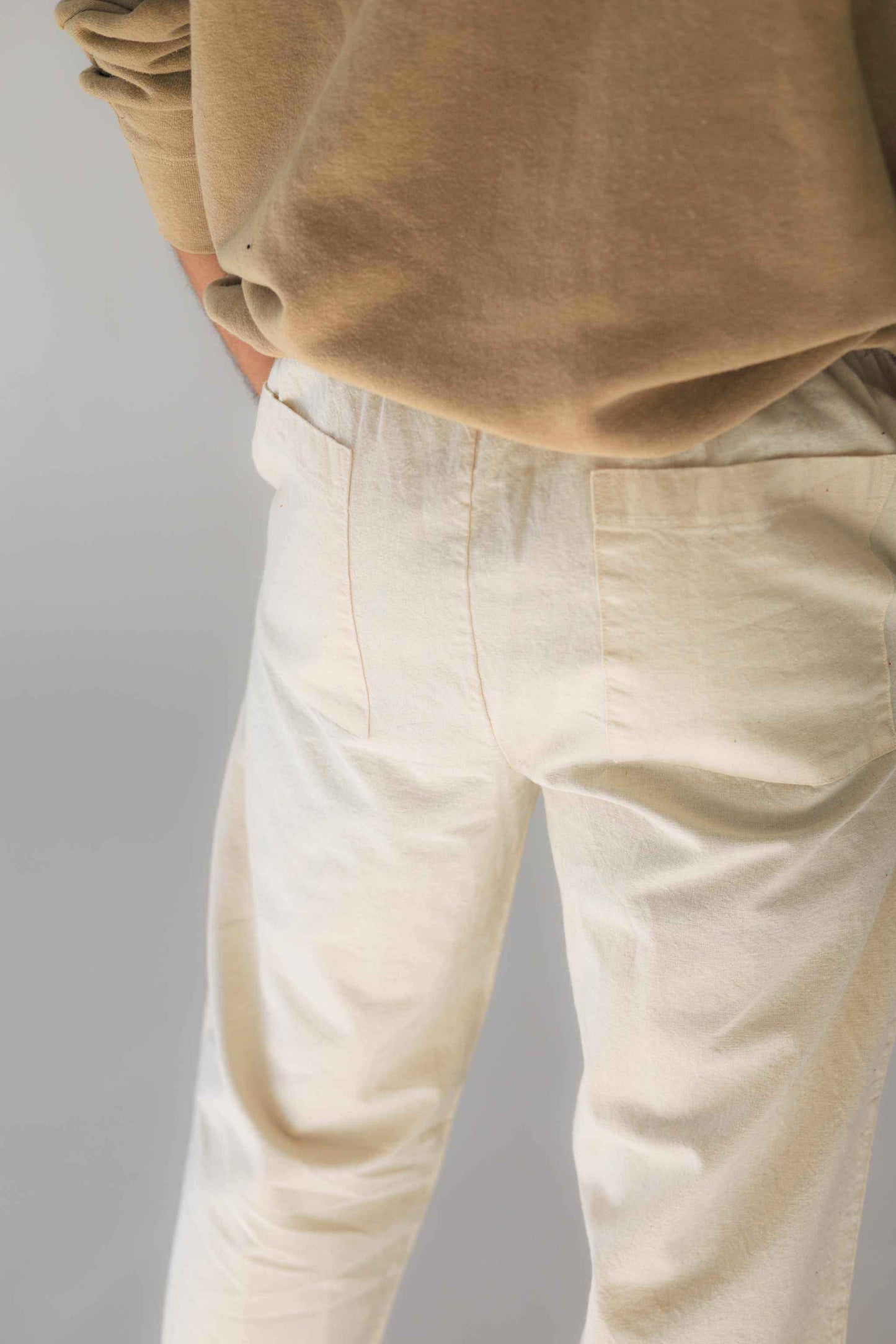 Unisex hemp linen and organic cotton pants with a relaxed fit, shown in linen white color, featuring a comfortable elastic waistband.