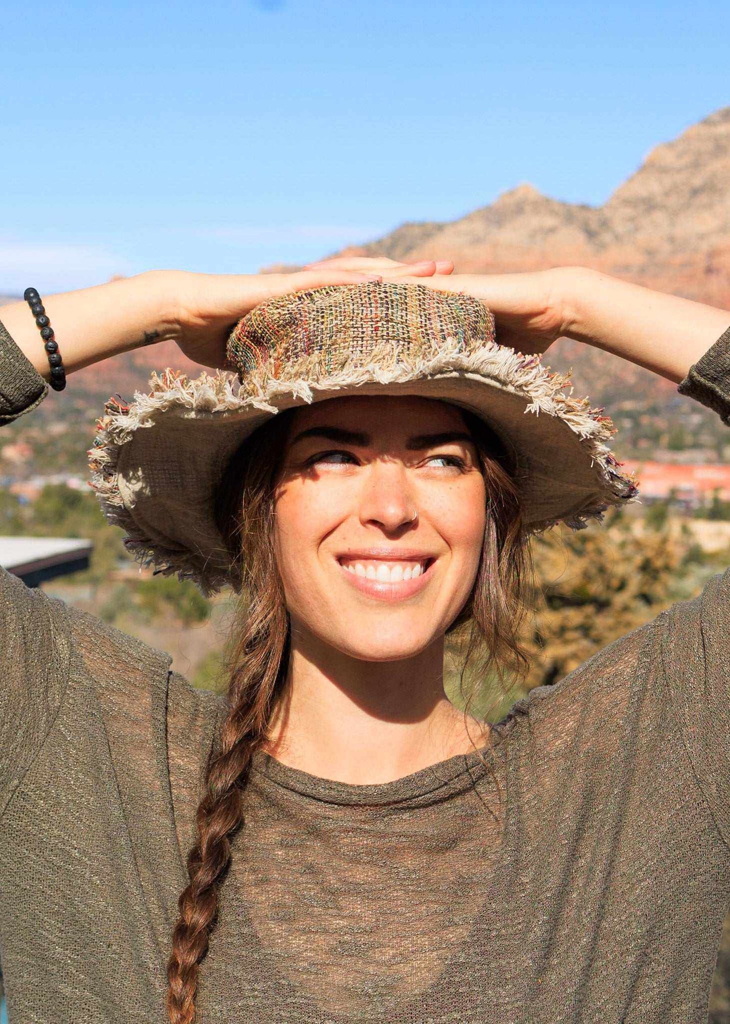 Woman wearing a hemp sun hat with neutral stripe, ideal for summer protection.