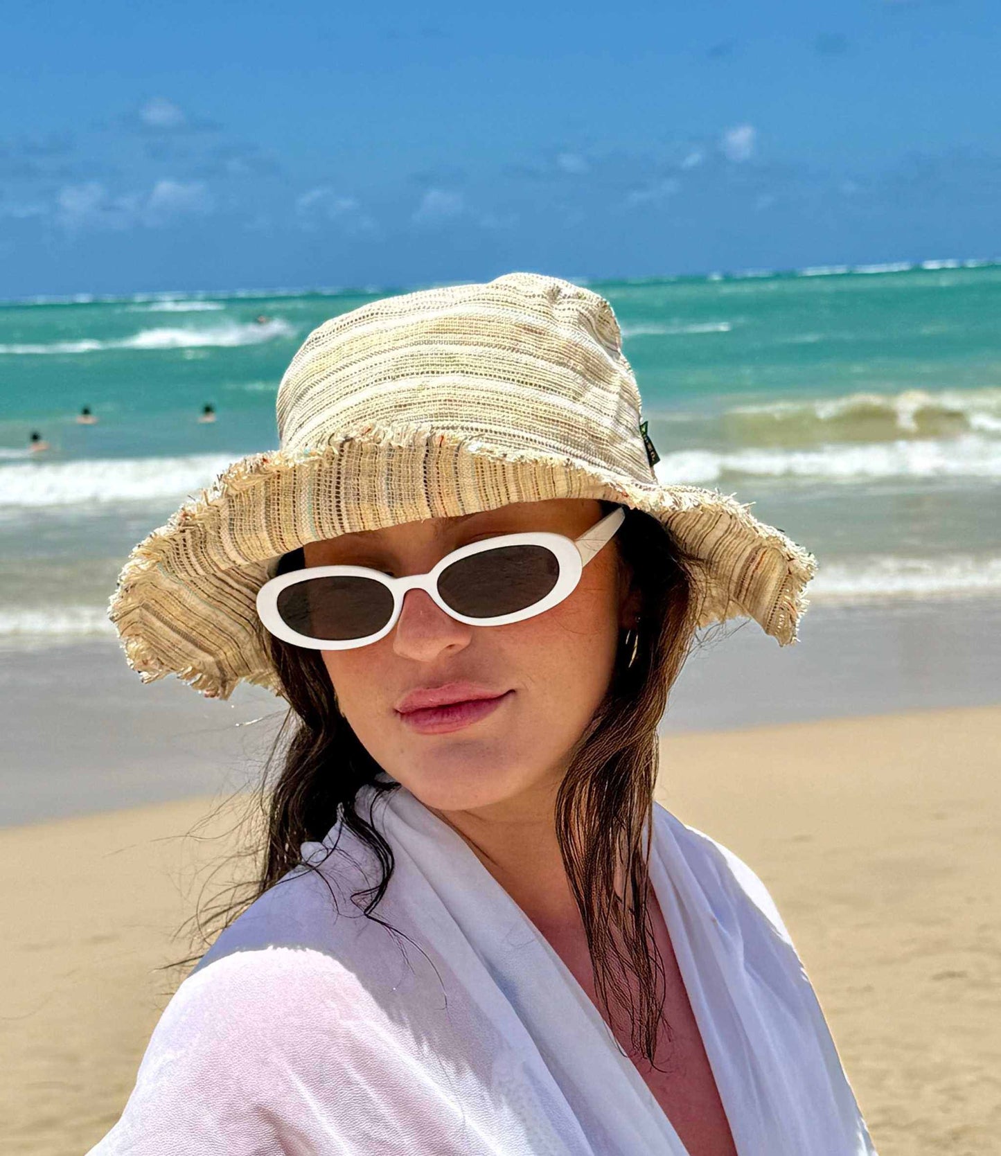 Handmade hemp linen sun hat with wide brim on a beach.