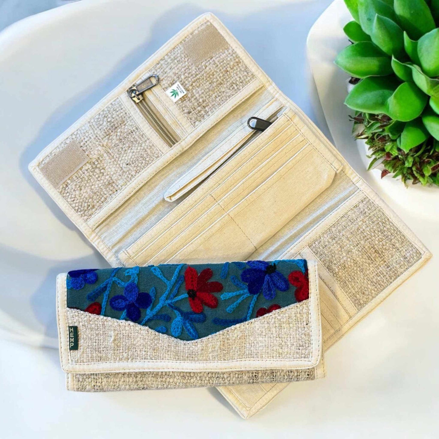 Women's hemp wallet with floral embroidery, tri-fold design, multiple compartments, sustainable vegan fabric.
