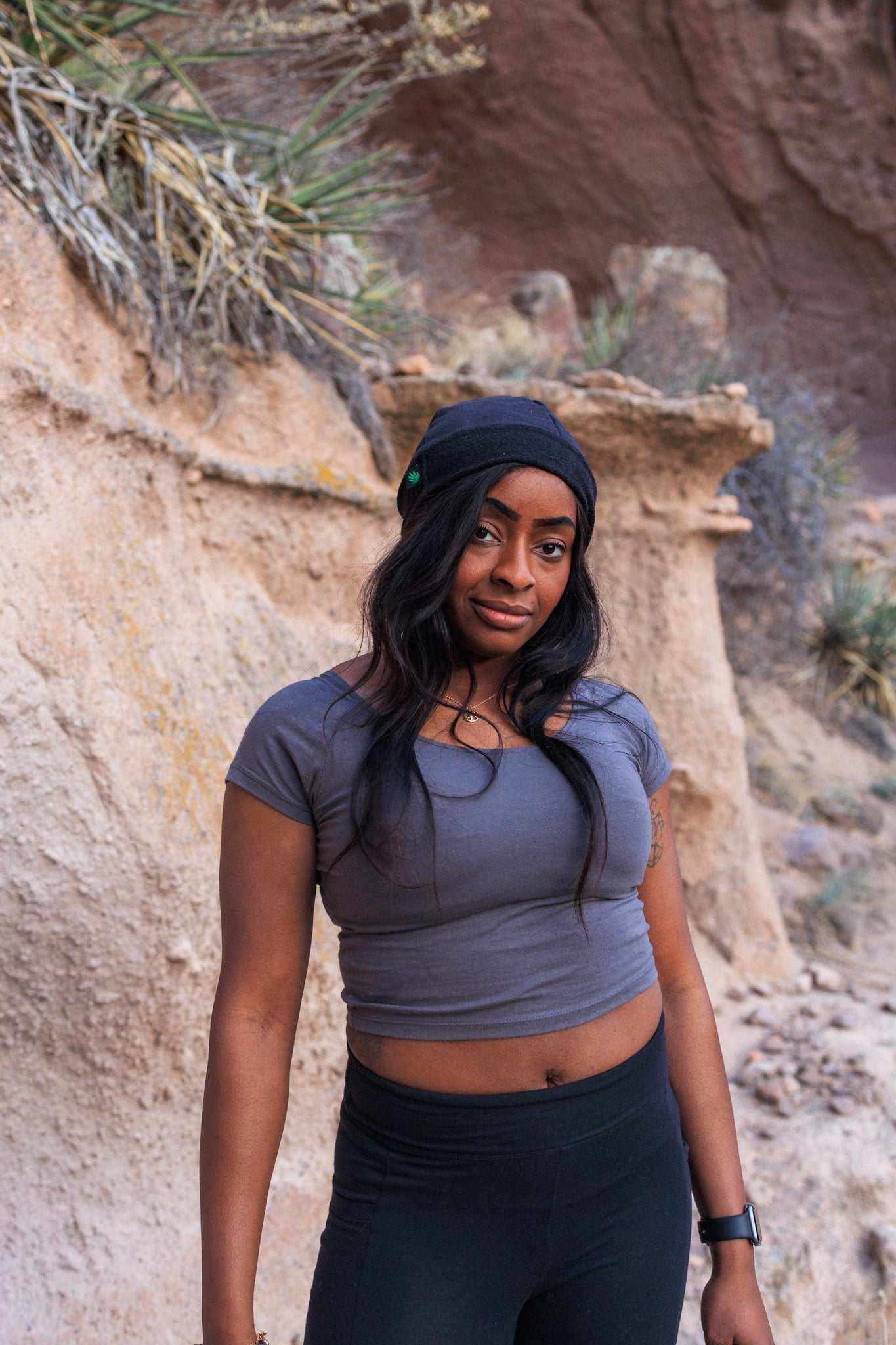 Woman wearing gray hemp cotton crop top with short sleeves and scoop neck, standing outdoors.