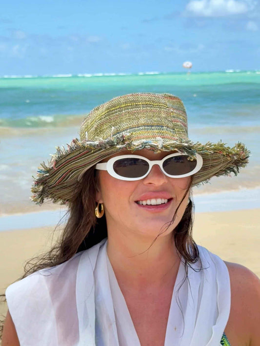 Woman wearing eco-friendly multi-color hemp hat with wide brim and white sunglasses on beach