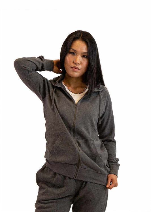 Woman wearing gray sustainable hemp and organic cotton zip-up hoodie with front pockets and drawstring hood