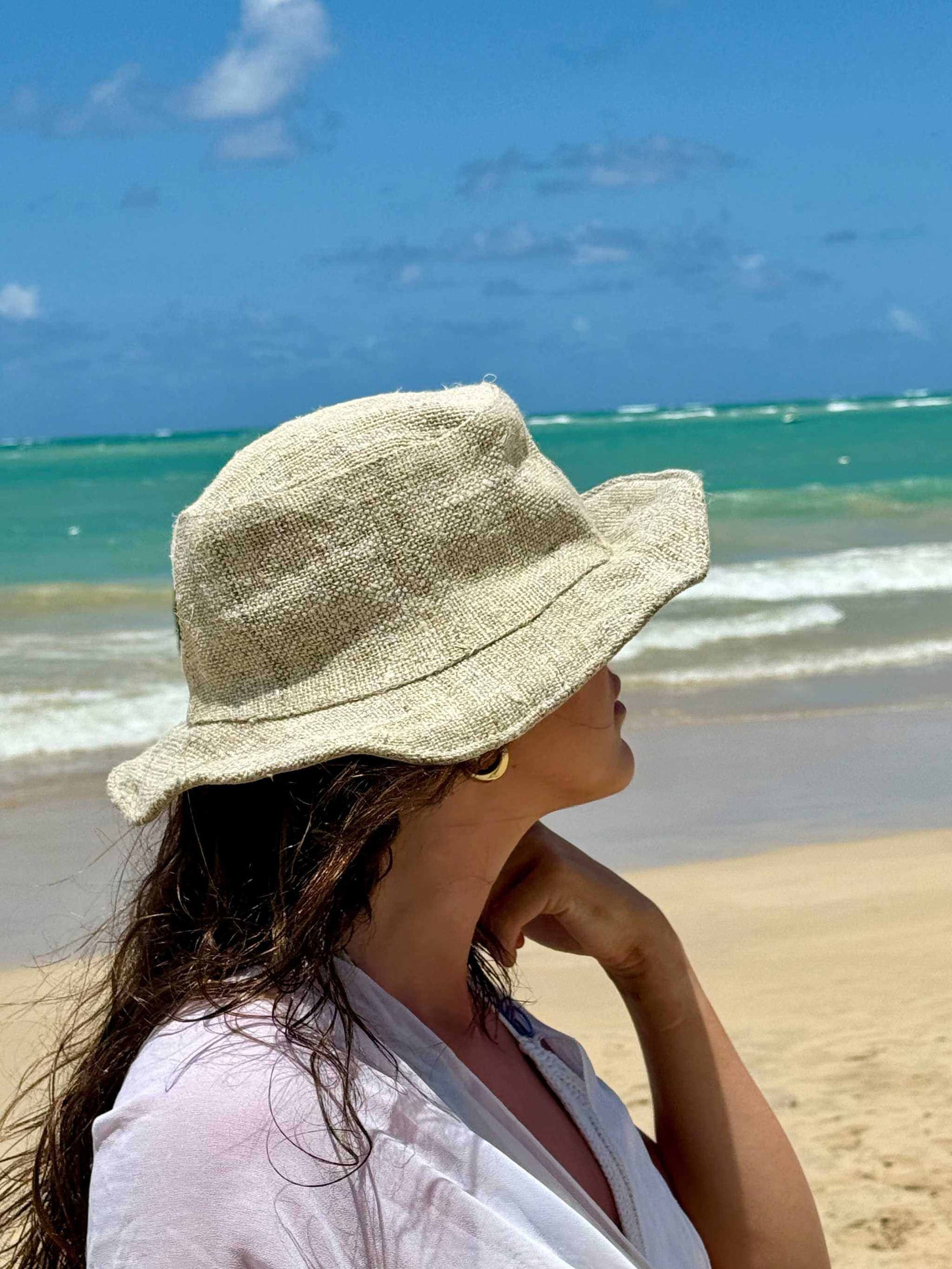 Handmade Natural Hemp Hat on woman at beach with ocean background.