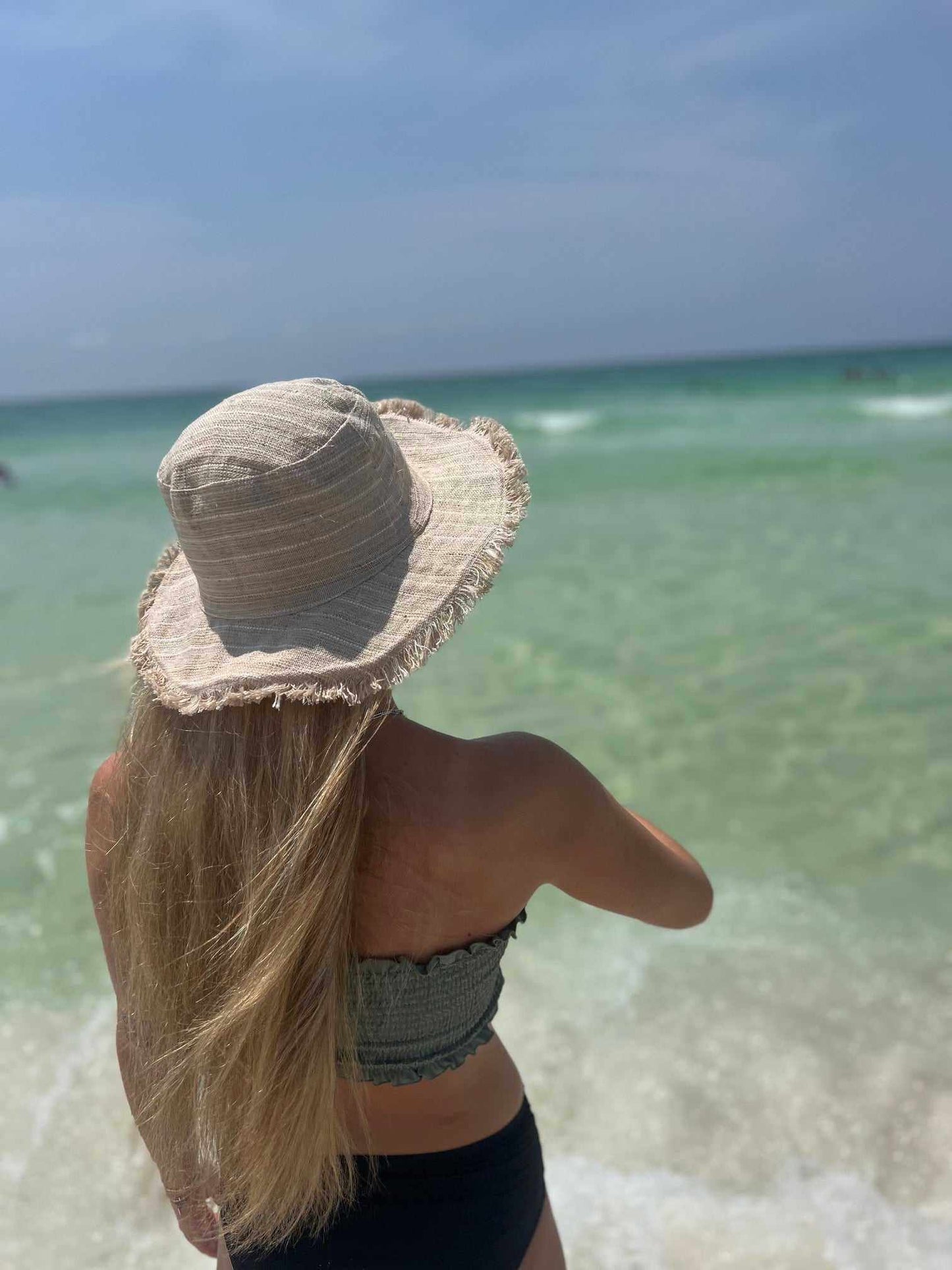 Hemp Linen Sun Hat in Neutral Stripe worn by the beach.