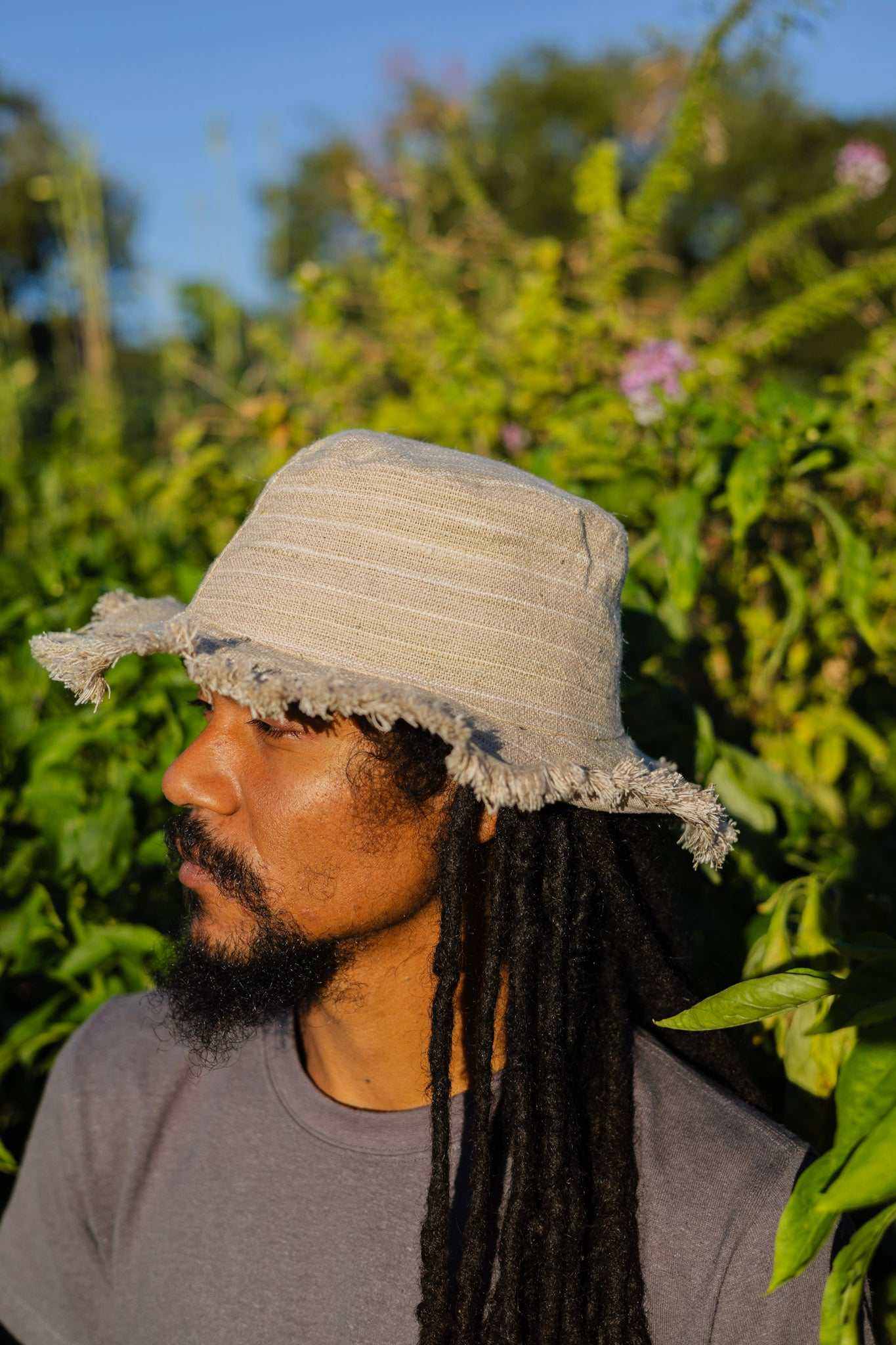 Hemp Linen Sun Hat in Neutral Stripe pattern, worn outdoors.