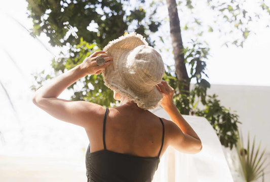 Woman wearing hemp linen sun hat in neutral stripe with wide brim outdoors