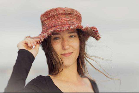 Hemp hat with striped pattern, worn by a person at the beach.