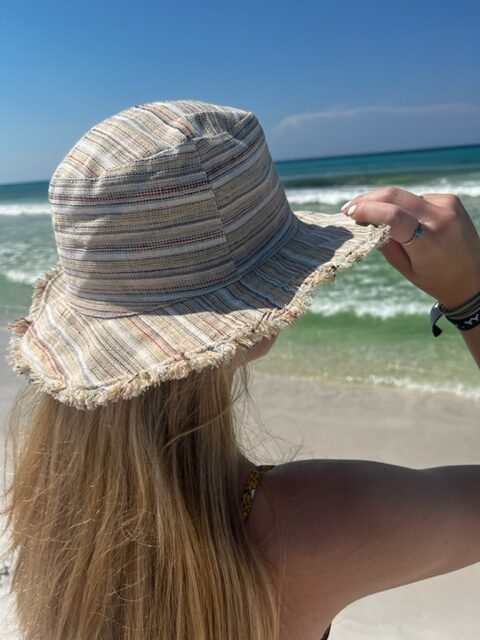 Hemp linen sun hat with wide brim worn on the beach.