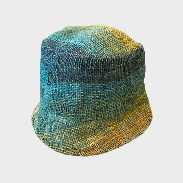 Rainbow hemp bucket hat on woman outdoors, showcasing vibrant colors and sustainable style.