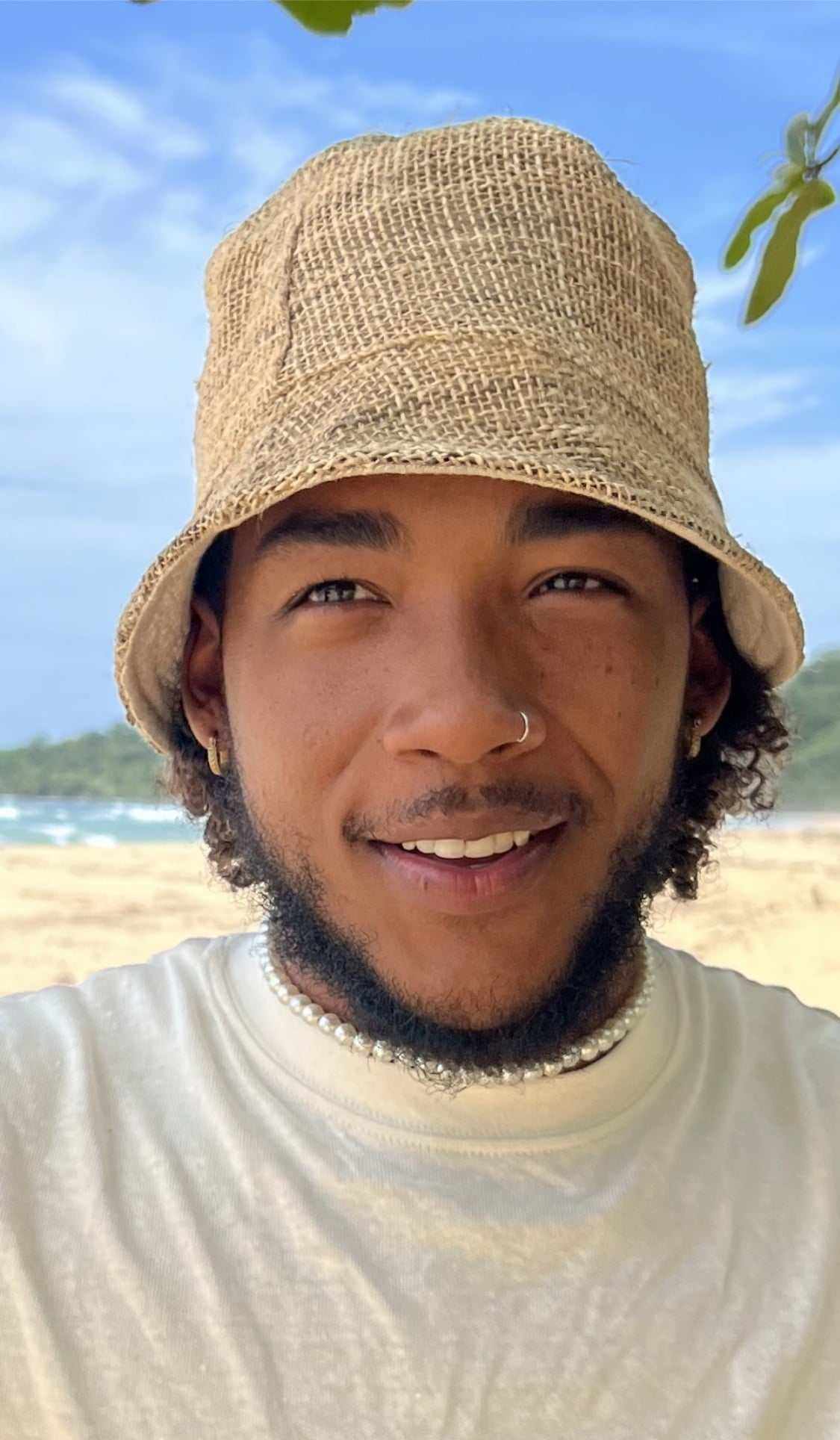Hemp bucket hat in natural color worn by a person at the beach.
