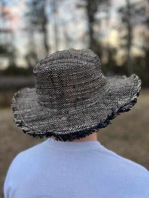 Adjustable wide brim hemp sun hat with frayed edges, worn outdoors