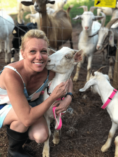 A person with goats wearing pink hemp goat collars.