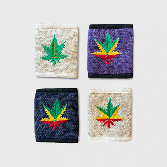 Set of handmade hemp bi-fold wallets with colorful hemp leaf designs in natural, blue, and purple colors.