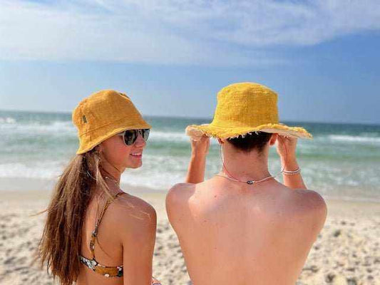 Hemp bucket hats in golden mustard on people at the beach.