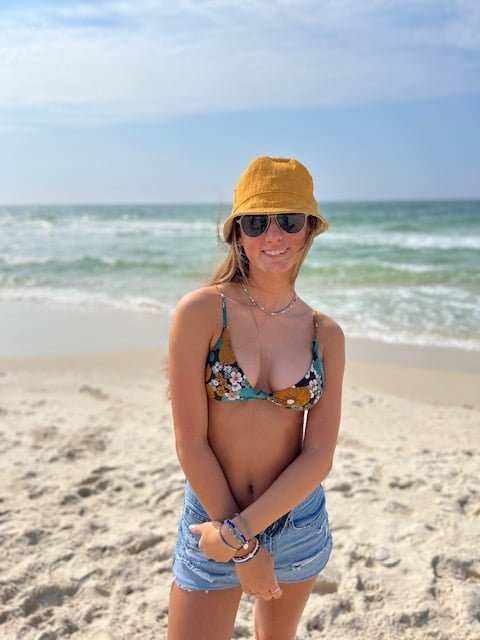 Hemp bucket hats in golden mustard on people at the beach.
