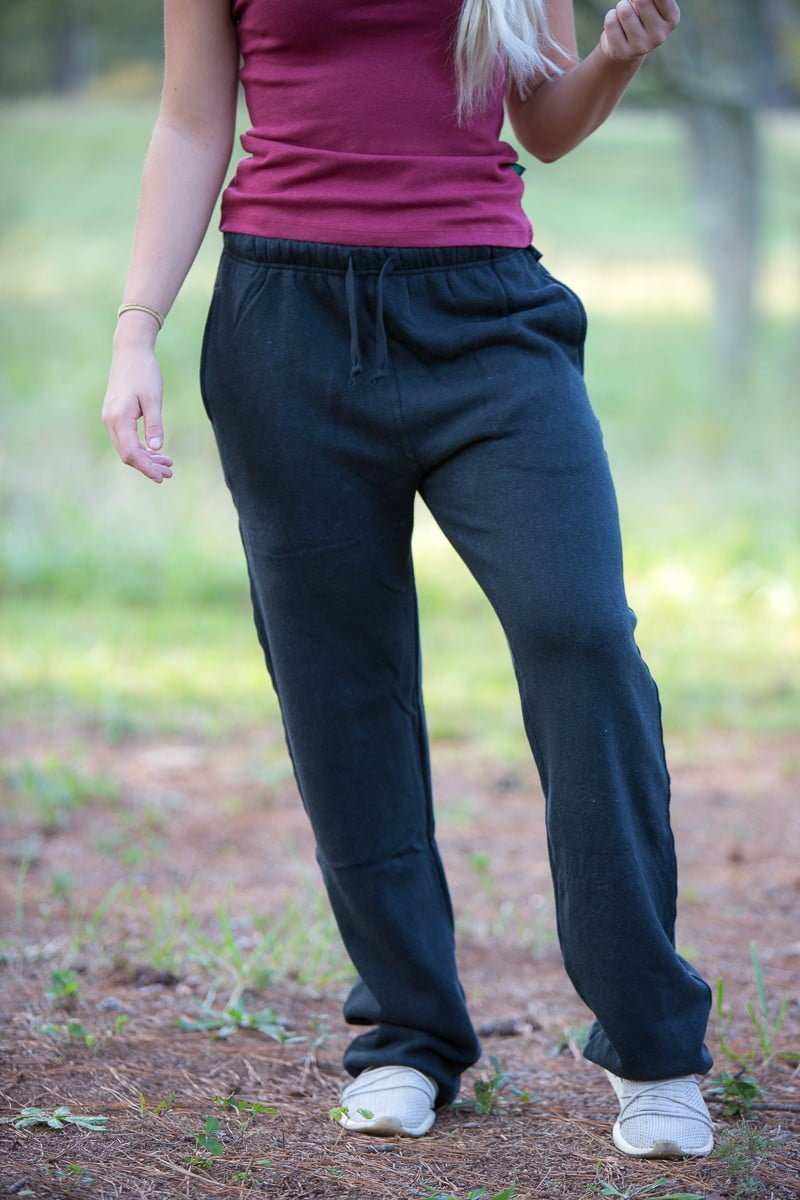 Person wearing dark blue sweatpants and a pink top outdoors.