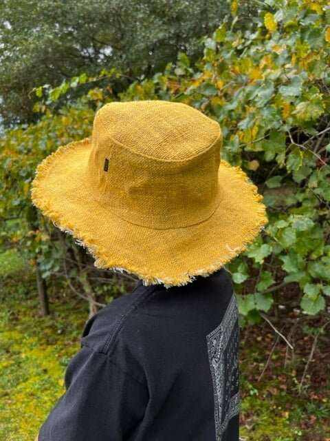 Hemp bucket hats in golden mustard on people at the beach.