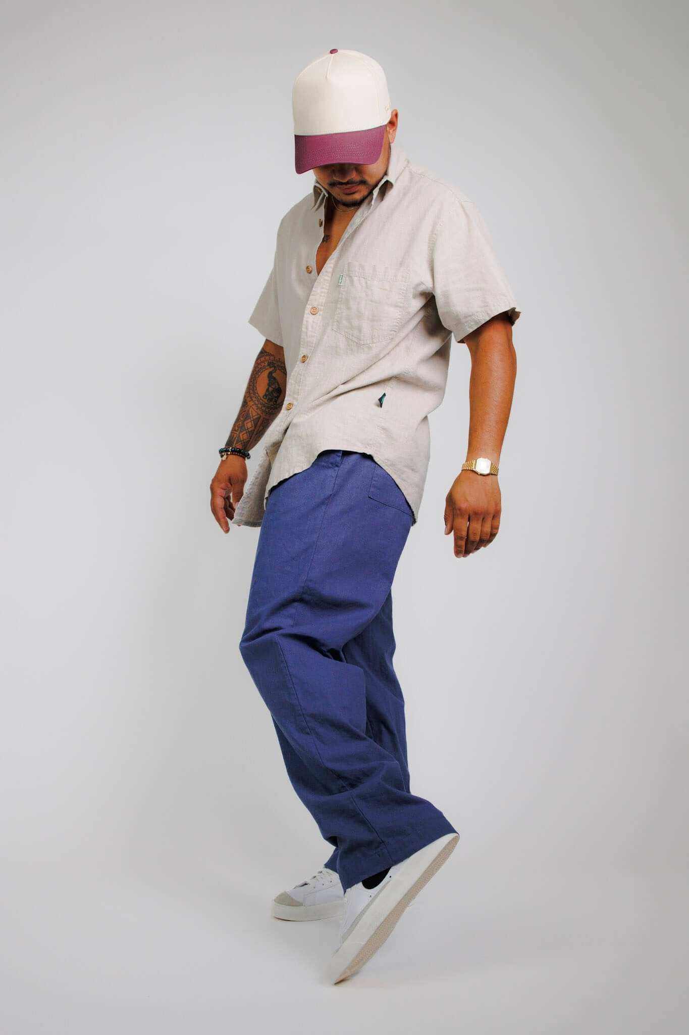 Unisex hemp linen and organic cotton pants in blue, eco-friendly and relaxed fit, worn with a casual shirt and cap.