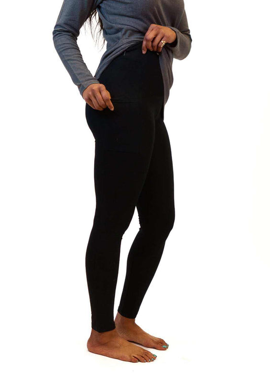 Woman wearing black sustainable hemp and cotton leggings with side pockets and a high-waisted yoga waistband.