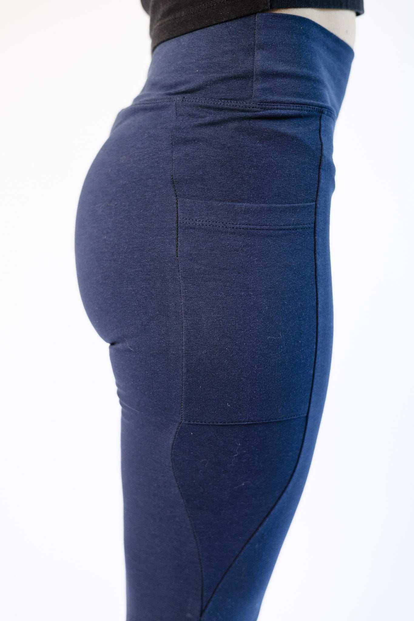 Close-up side view of navy blue hemp and cotton blend leggings with deep side pocket and high waistband.