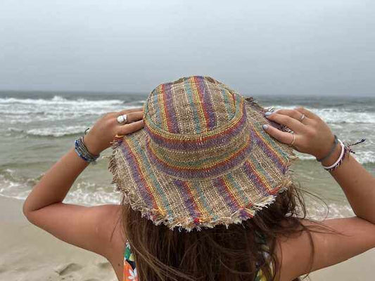 Hemp sun hat with multi-color stripes being worn at the beach.