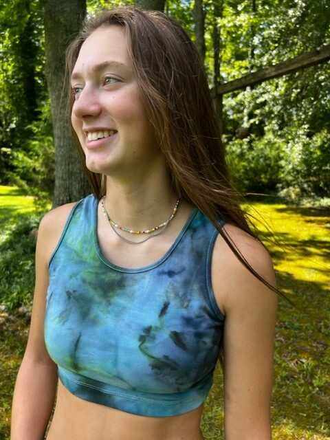 woman wearing blue-green tie dye hemp bralette outdoors in forest setting
