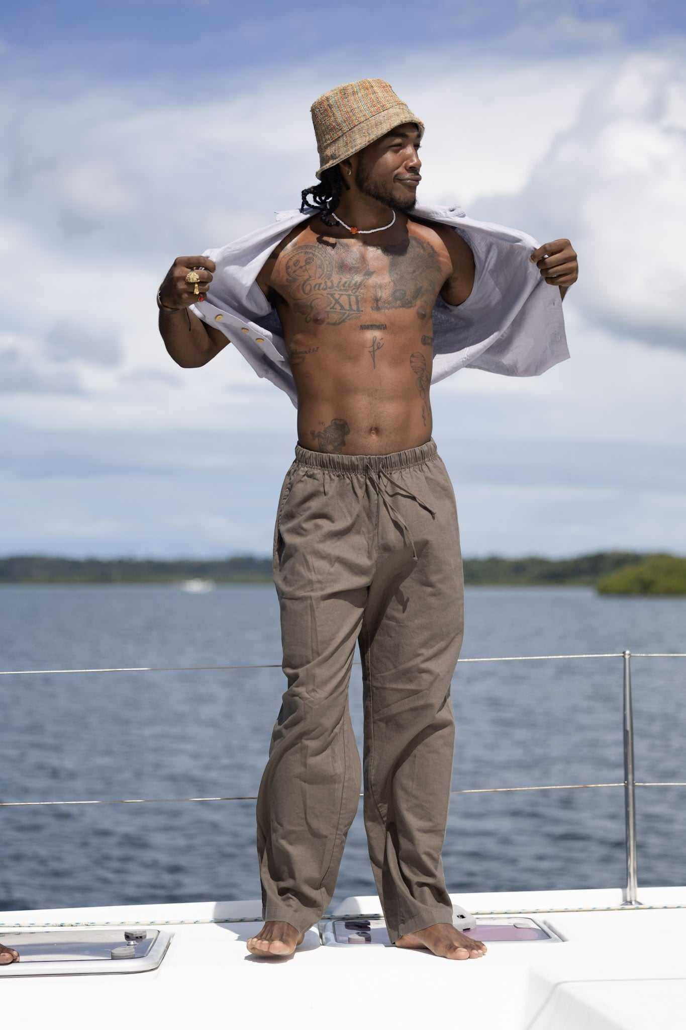 Unisex hemp linen and organic cotton pants worn by a person standing on a boat, showcasing a relaxed fit and natural earthy style.