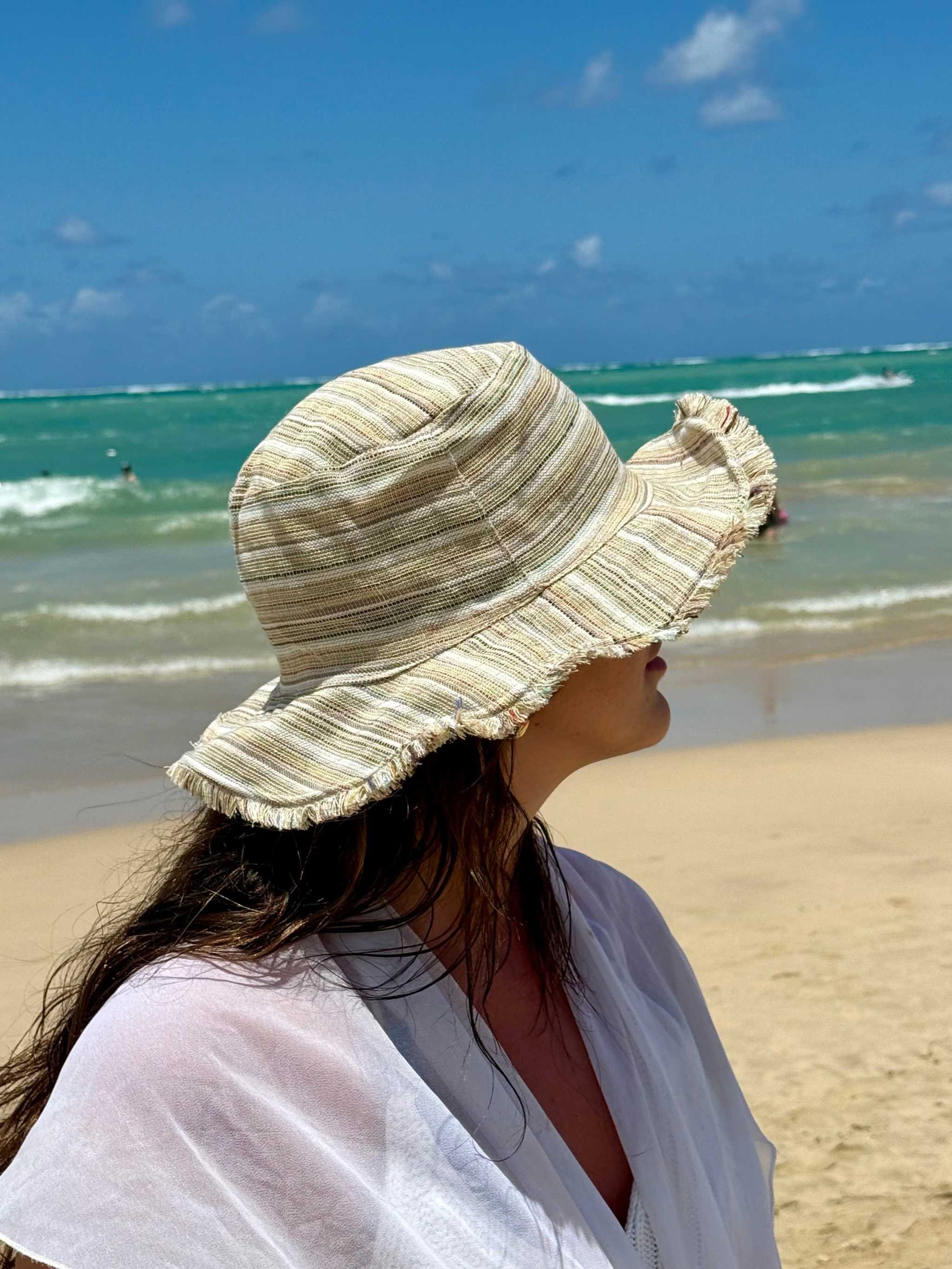 Handmade hemp linen sun hat with wide brim and neutral stripes, perfect for summer beach outings.