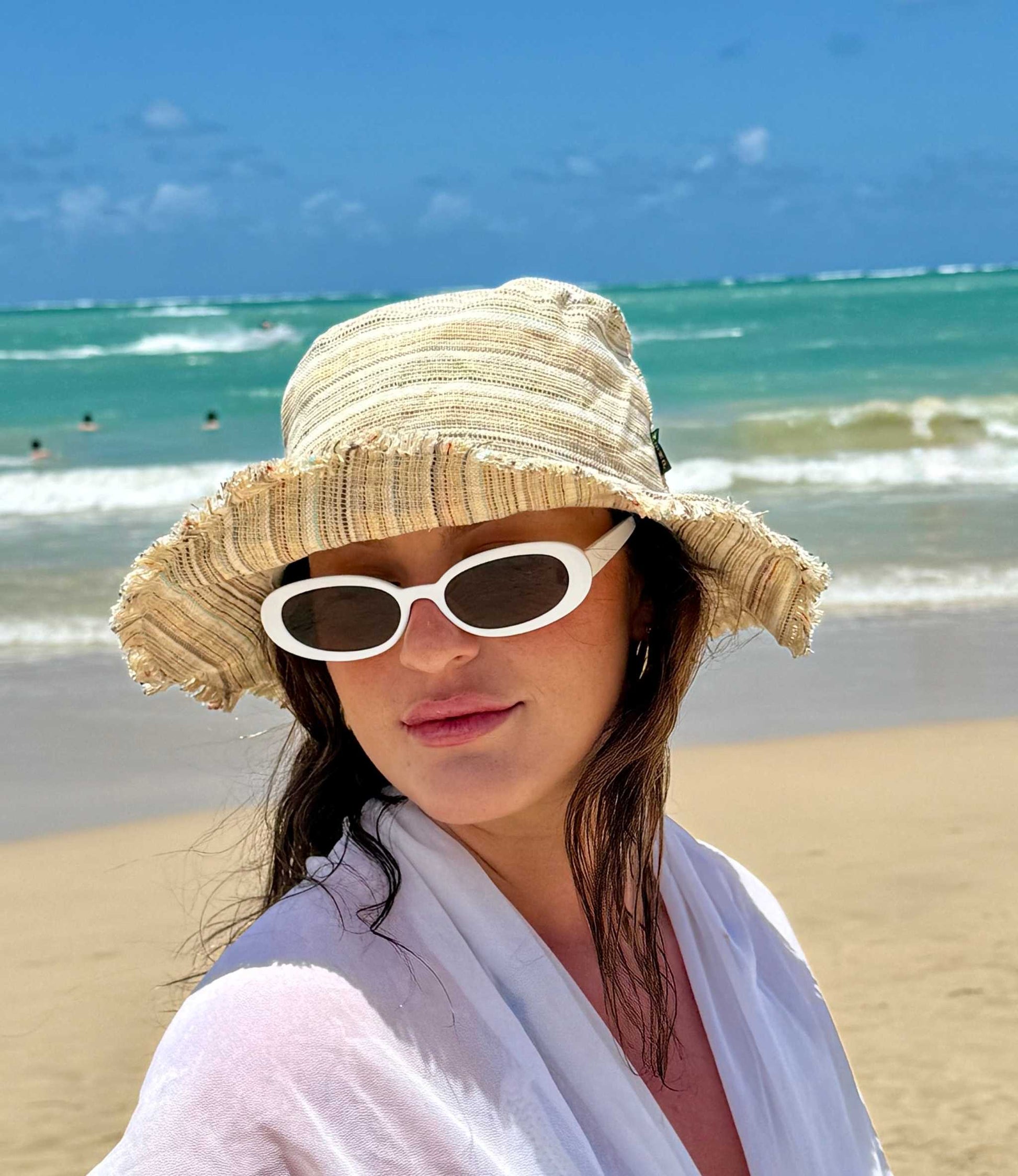 Handmade hemp linen sun hat with wide brim on a beach.