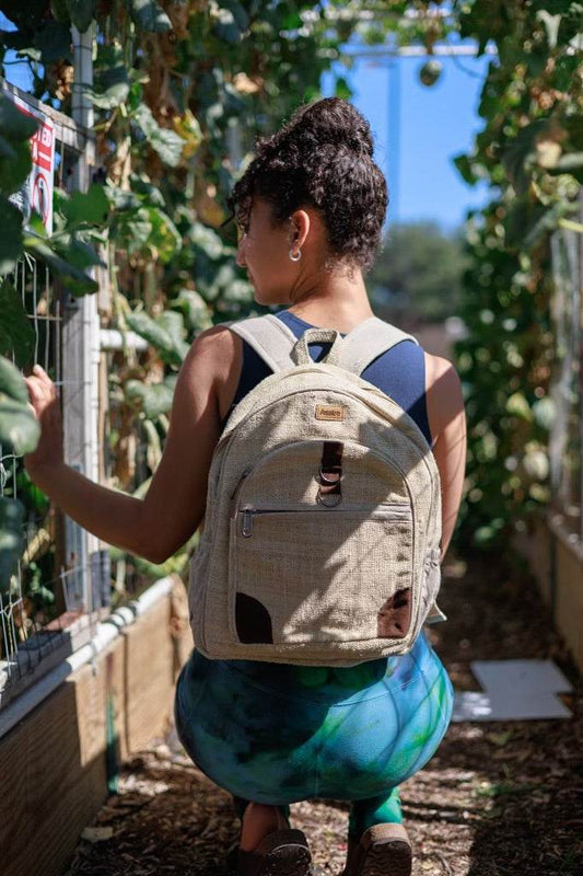 Woman wearing natural Himalayan handmade hemp backpack outdoors with plants in background
