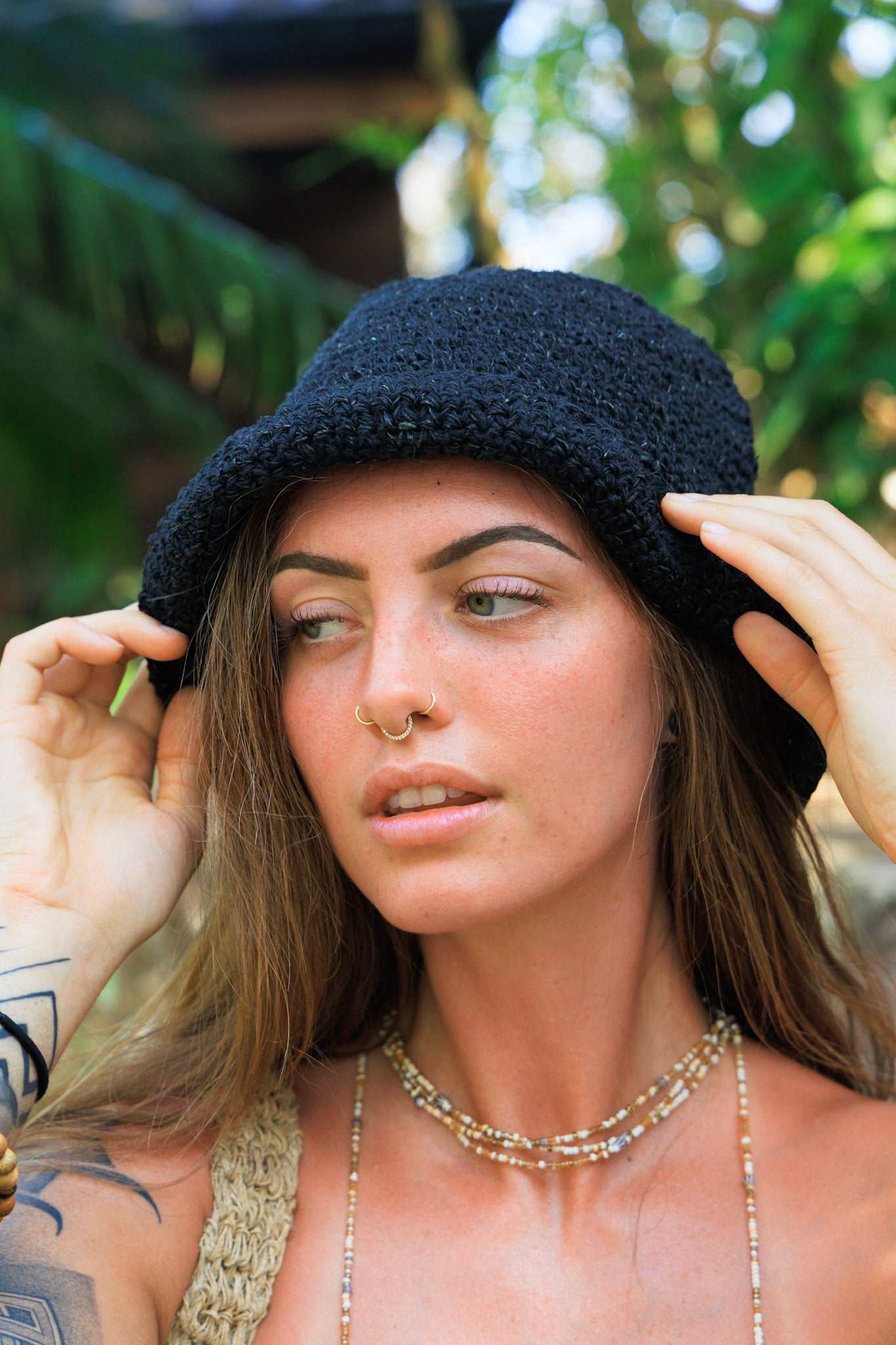 Woman wearing a black knit hat with a blurred natural background