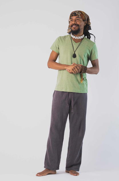 Person wearing a green t-shirt and gray pants on a white background