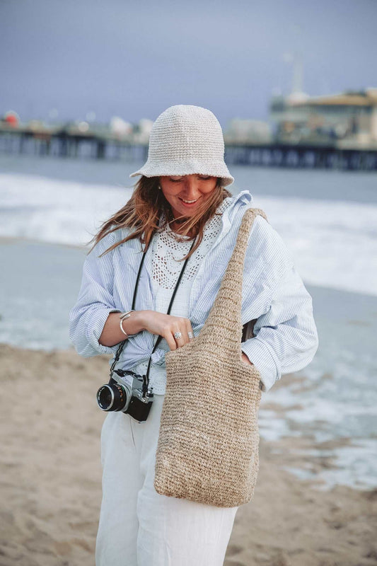 Handmade foldable hemp beach hat with wide brim, natural beige crochet design for sun protection and summer travel