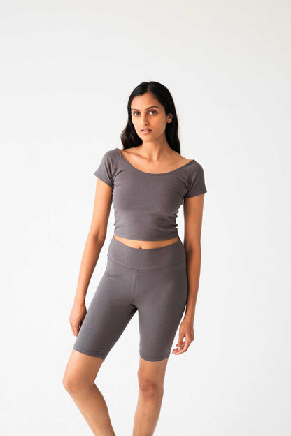 Woman wearing a gray athletic outfit on a white background