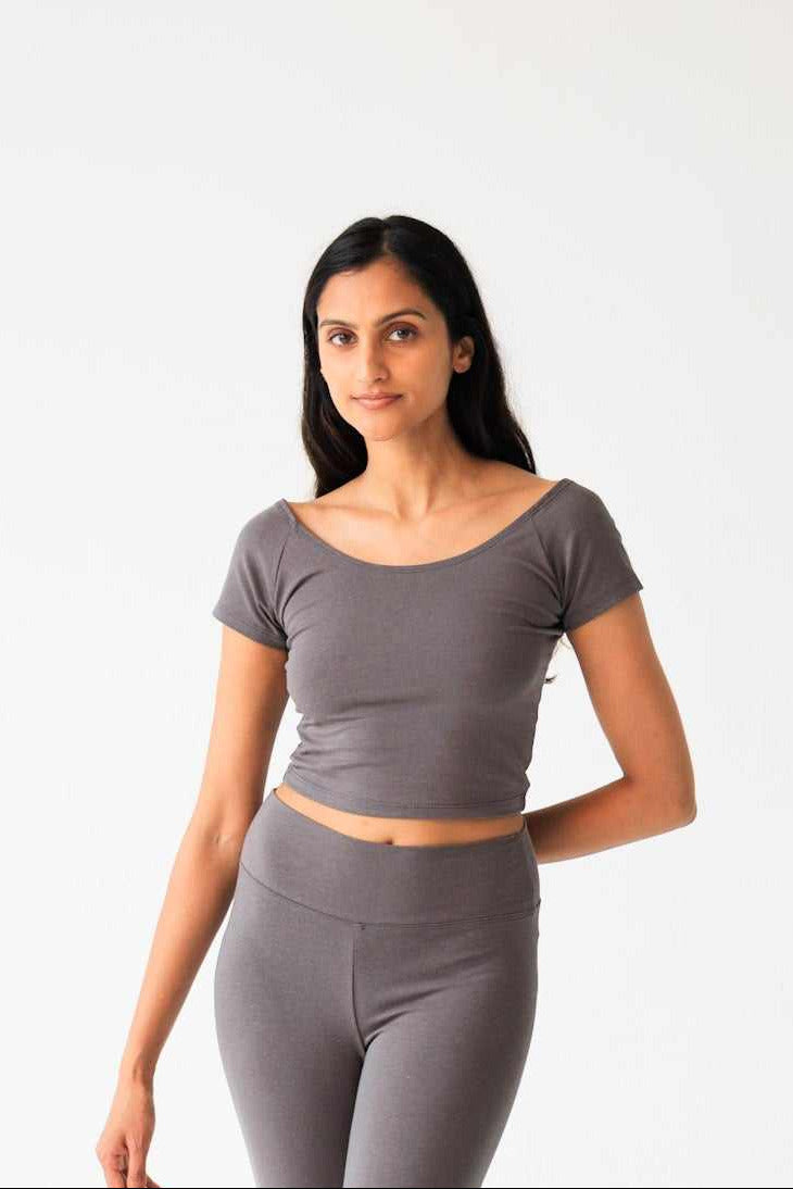 Woman wearing a gray athletic outfit on a white background