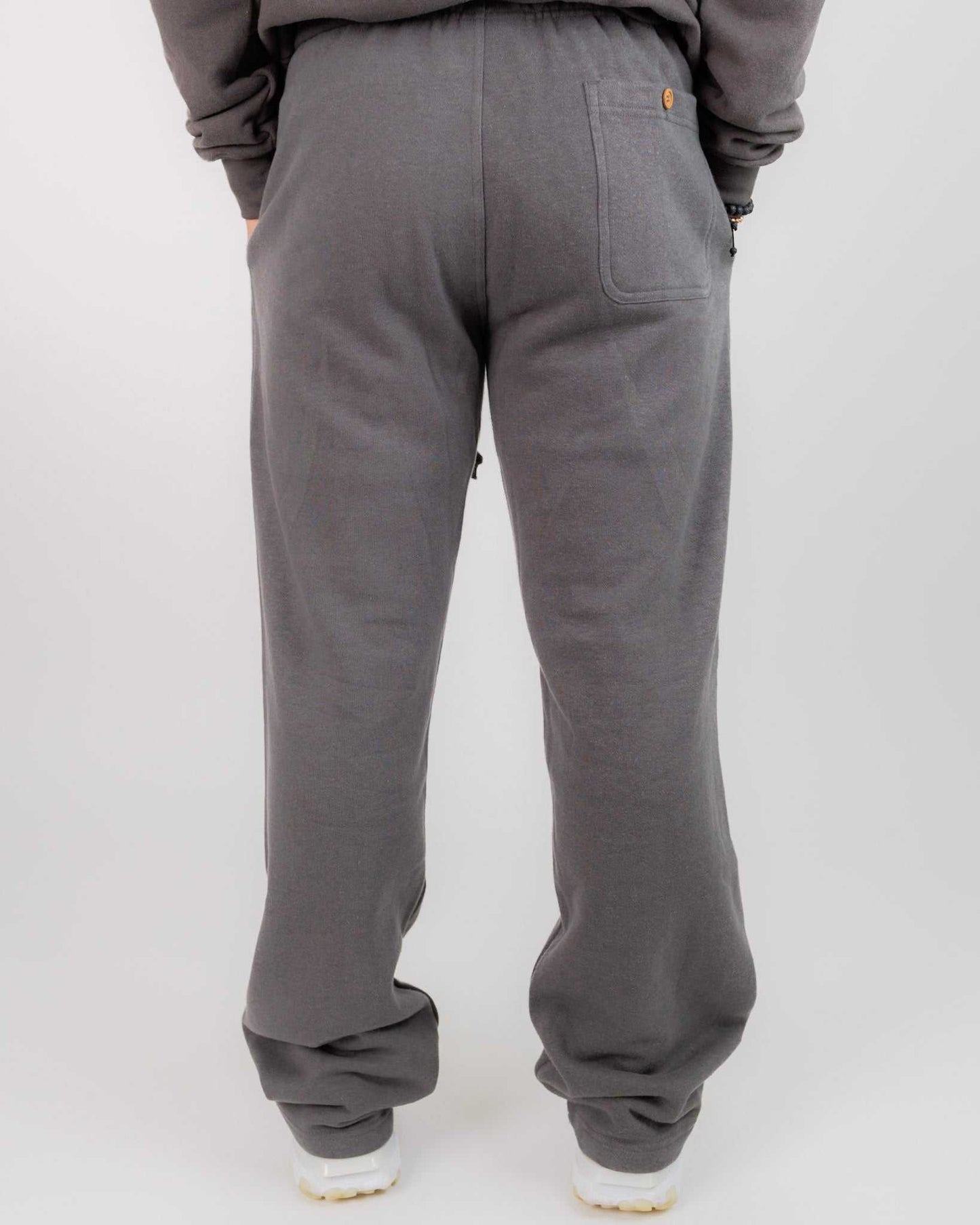 Gray sweatpants worn by a person on a white background