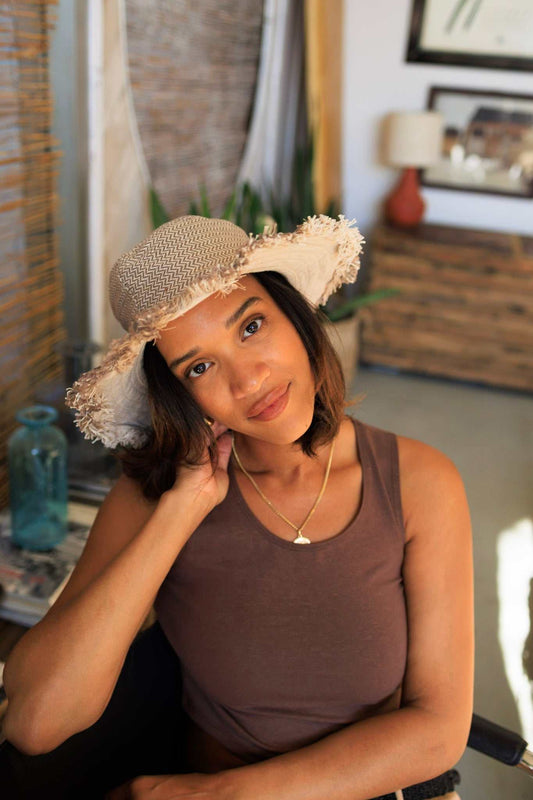 Woman wearing eco-friendly hemp linen herringbone sun hat with frayed edges indoors