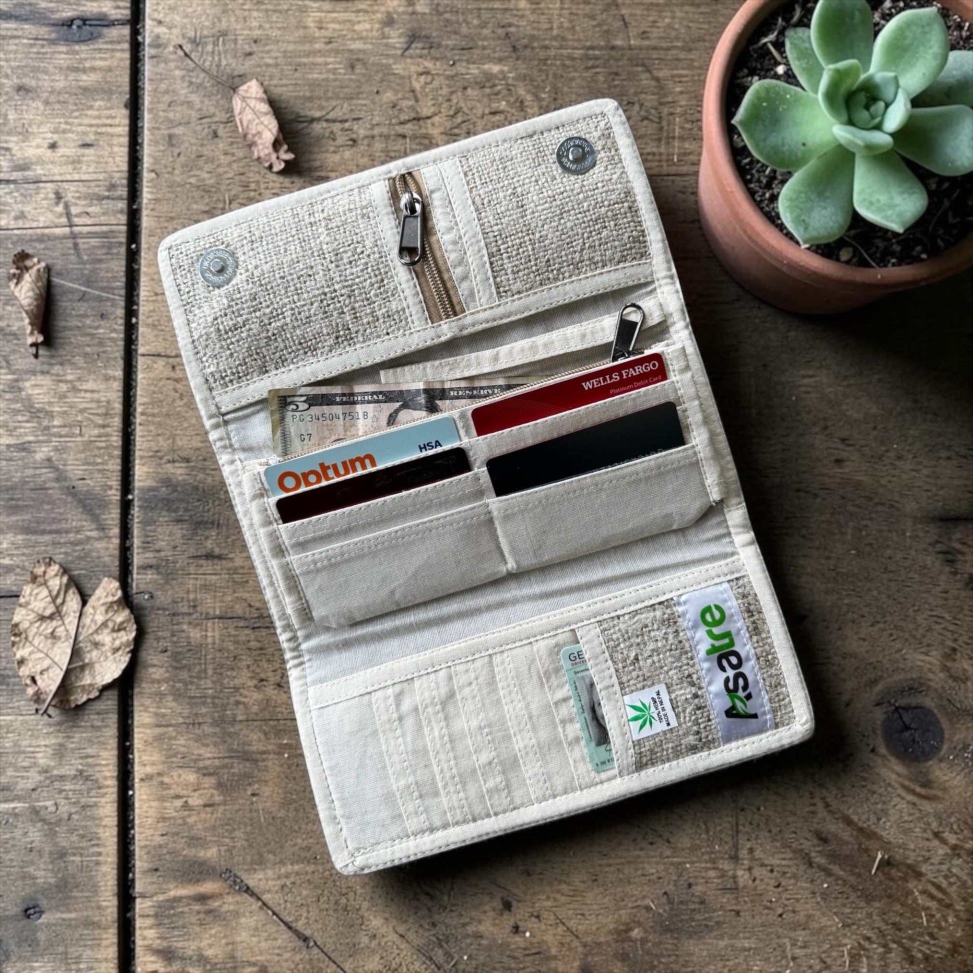 Handmade hemp wallet with purple, pink, and green floral embroidery in a sustainable, vegan tri-fold design