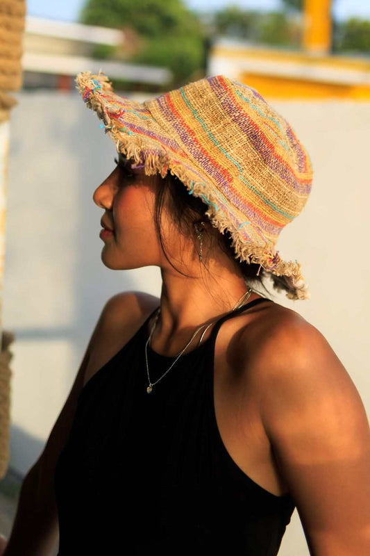 Woman wearing eco-friendly multi color striped hemp sun hat with frayed edges outdoors