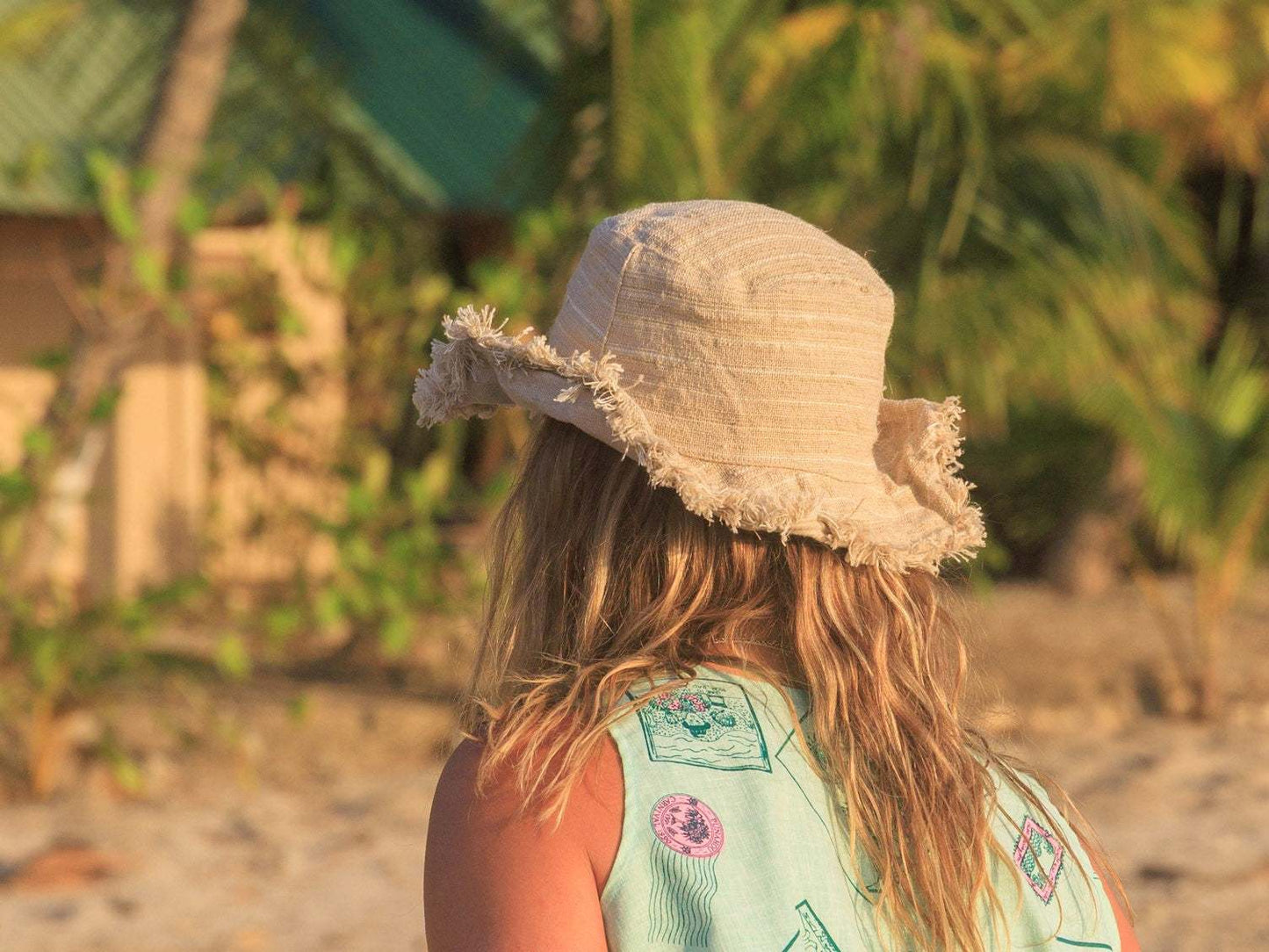 Hemp Linen Sun Hat in Neutral Stripe pattern, worn outdoors.
