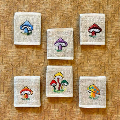Eco-friendly hemp bi-fold wallets with colorful mushroom embroidery, handmade from durable hemp fabric.