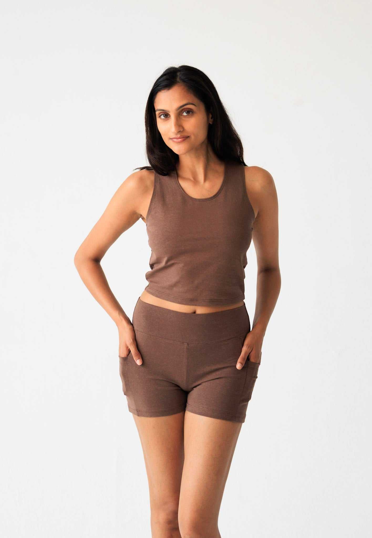 Woman wearing brown hemp cotton yoga shorts with pockets and matching tank top