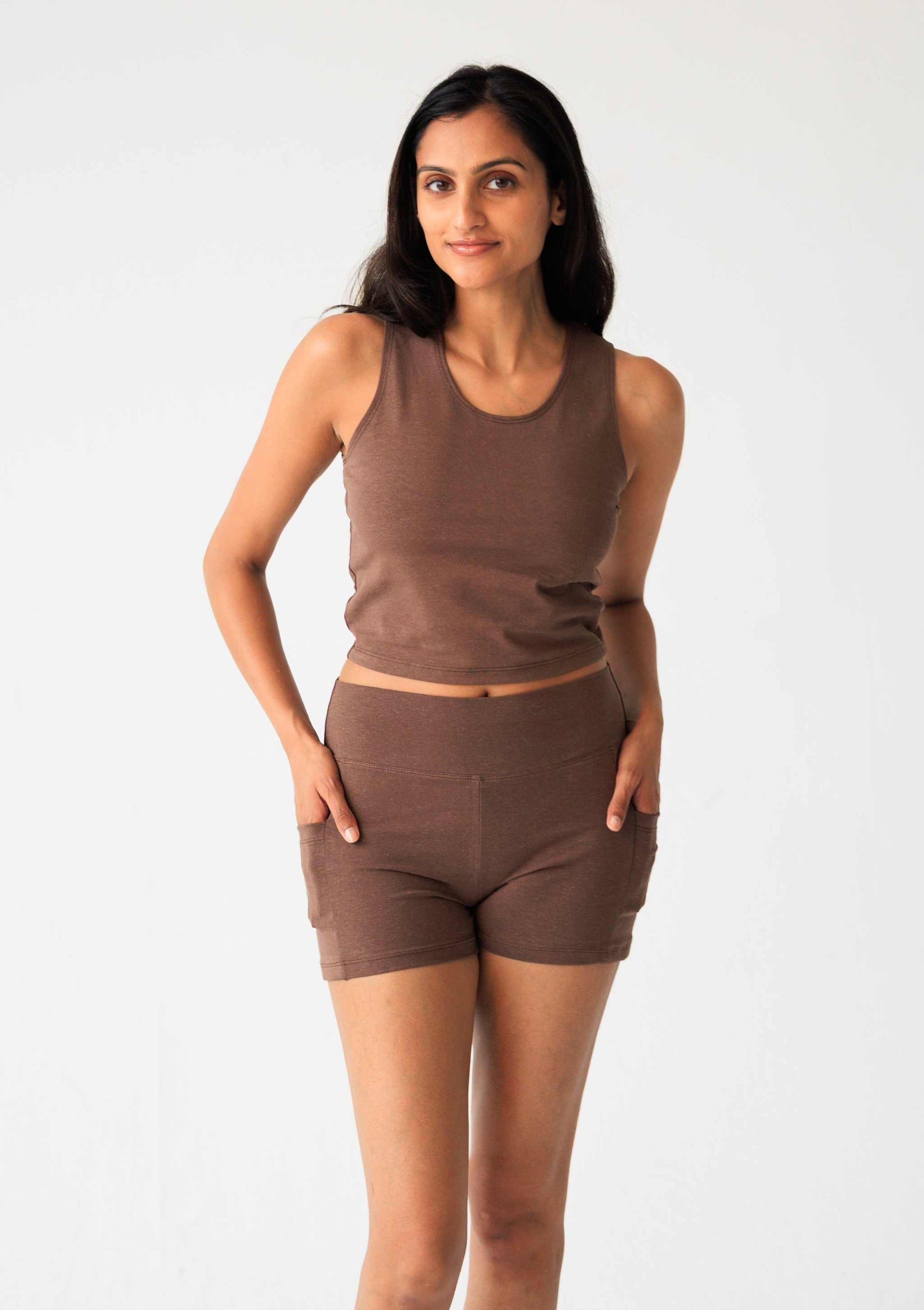 Woman wearing a brown tank top and shorts set on a white background
