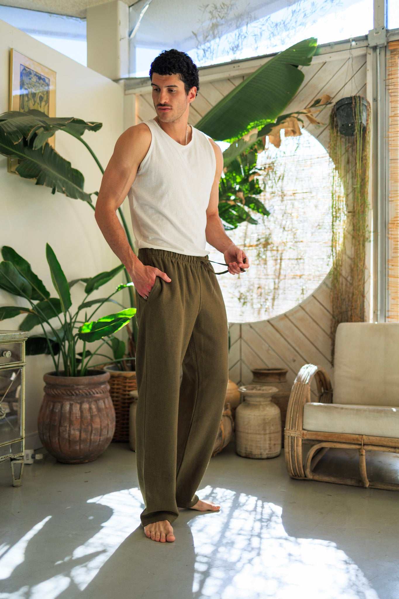 Tall men's olive hemp fleece sweatpants with elastic waistband and drawstring worn indoors