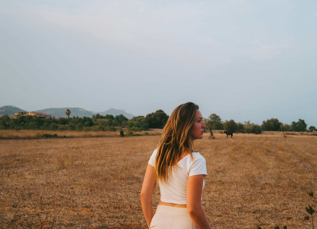 Cotton Crop Top in white, fitted with short sleeves and a cropped hem, worn with light-colored bottoms