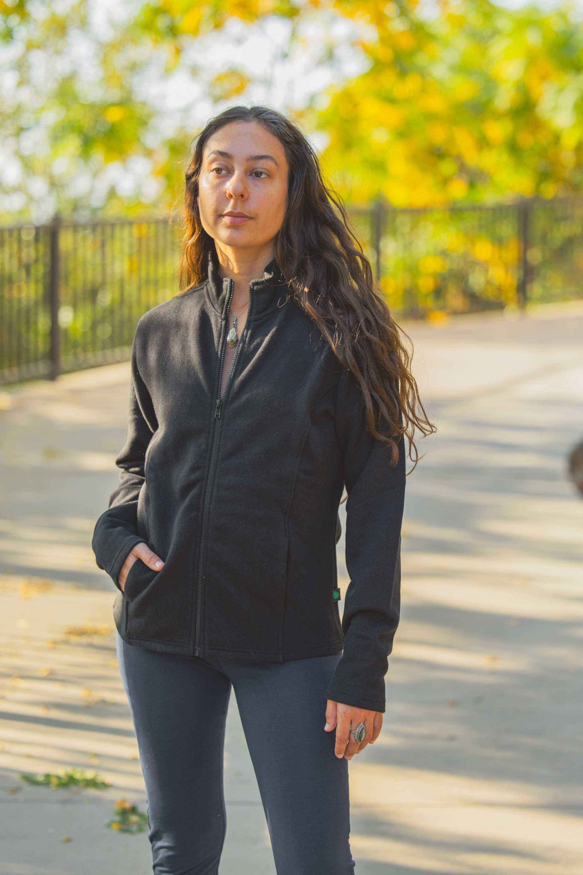 Hemp Jacket in black fleece with a stand collar, full zip front, and vertical pockets, worn by a woman